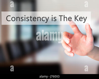 La coerenza è la chiave - Mano premendo un pulsante sul fondo sfocato concetto . Business, tecnologia internet concetto. Stock Photo Foto Stock