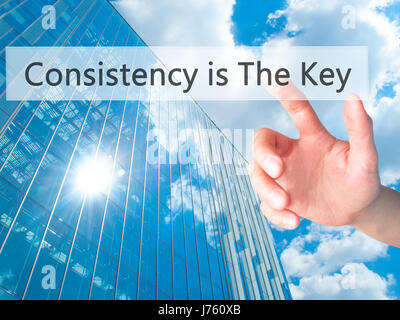 La coerenza è la chiave - Mano premendo un pulsante sul fondo sfocato concetto . Business, tecnologia internet concetto. Stock Photo Foto Stock