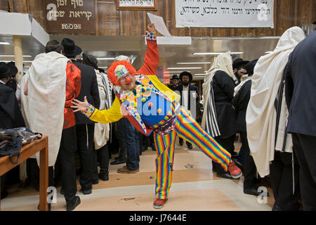 Religiosa ebraica uomini celebrare la festa di Purim, una vacanza dove i costumi sono tradizionalmente consumati. In una sinagoga in Crown Heights, Brooklyn, New York Foto Stock