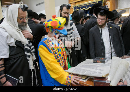 Religiosa ebraica uomini celebrare la festa di Purim, una vacanza dove i costumi sono tradizionalmente consumati. In una sinagoga in Crown Heights, Brooklyn, New York Foto Stock