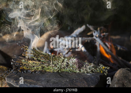 Räuchern am Lagerfeuer, Räucherbündel, Räucherbüschel, Räucherritual, Sommersonnenwende, Räuchern mit Kräutern, Kräuter verräuchern, Wildkräuter, Duft Foto Stock