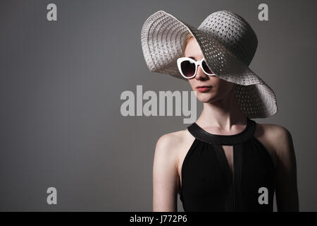 Giovane bella moda donna con il trucco alla moda. Modello guardando la telecamera, indossando occhiali elegante, hat. Moda femminile, il concetto di bellezza Foto Stock