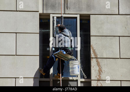 Uomo di pulizia utilizzando Windows calata alle tecniche di cordata Washington DC USA Foto Stock