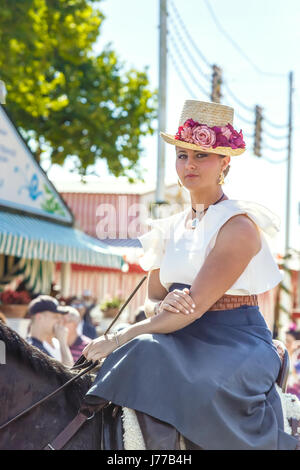 Siviglia, Spagna - Maggio 02, 2017: splendida e romantica giovane donna a cavallo di Siviglia la fiera di aprile. Foto Stock