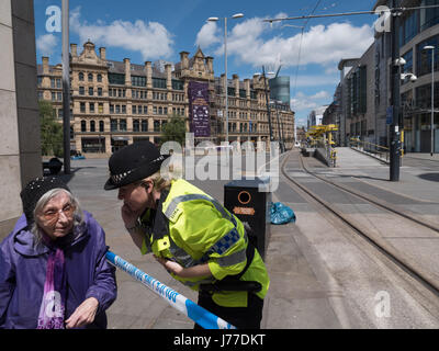 Funzionario di polizia a parlare con una vecchia signora presso il cordone al di fuori del centro commerciale Arndale in Manchester City Centre il giorno dopo un attentato suicida ha ucciso 22 come folle sono state lasciando il Ariana Grande concerto presso l'Arena di Manchester. Credito: Chris Rogers/Alamy Live News Foto Stock