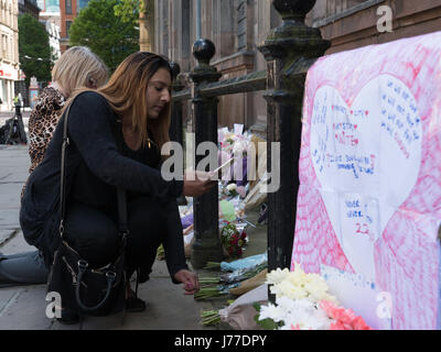 Manchester, Regno Unito. 23 Maggio, 2017. Persone in lutto delle preghiere e dei laici a omaggi floreali per i morti al di fuori di San rna chiesa nel centro della città di Manchester, il giorno dopo un attentato suicida ha ucciso 22 come folle sono state lasciando il Ariana Grande concerto presso l'Arena di Manchester. Credito: Chris Rogers/Alamy Live News Foto Stock