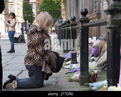 Manchester, Regno Unito. 23 Maggio, 2017. Persone in lutto delle preghiere e dei laici a omaggi floreali per i morti al di fuori di San rna chiesa nel centro della città di Manchester, il giorno dopo un attentato suicida ha ucciso 22 come folle sono state lasciando il Ariana Grande concerto presso l'Arena di Manchester. Credito: Chris Rogers/Alamy Live News Foto Stock