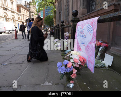 Manchester, Regno Unito. 23 Maggio, 2017. Persone in lutto delle preghiere e dei laici a omaggi floreali per i morti al di fuori di San rna chiesa nel centro della città di Manchester, il giorno dopo un attentato suicida ha ucciso 22 come folle sono state lasciando il Ariana Grande concerto presso l'Arena di Manchester. Credito: Chris Rogers/Alamy Live News Foto Stock