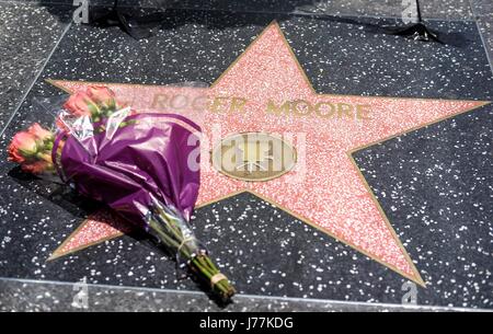 Los Angeles, Stati Uniti d'America. 23 Maggio, 2017. I fiori sono posizionati sulla Hollywood Walk of Fame stella di Roger Moore in Los Angeles, gli Stati Uniti, il 23 maggio 2017. Moore, meglio conosciuto per il suo ruolo di film di James Bond, morì di cancro all'età di 89 in Svizzera dove ha vissuto la sua famiglia ha detto in una dichiarazione il martedì. Credito: Zhao Hanrong/Xinhua/Alamy Live News Foto Stock