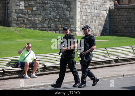 Windsor, Regno Unito. Xxiv Maggio, 2017. Armati pesantemente e funzionari di polizia pattuglia di fronte al Castello di Windsor. La cerimonia del Cambio della guardia dal 1° Battaglione delle guardie Coldstream è stato annullato questa mattina con breve preavviso in risposta al sollevamento del livello di minaccia di grave a critica da parte del comune di terrorismo Centro di valutazione ma di un numero maggiore di agenti di polizia sono stati in prova. Credito: Mark Kerrison/Alamy Live News Foto Stock