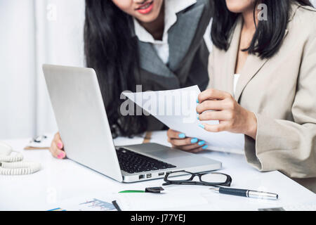 Close up di imprenditrici a discutere di lavorare sul computer in ufficio Foto Stock