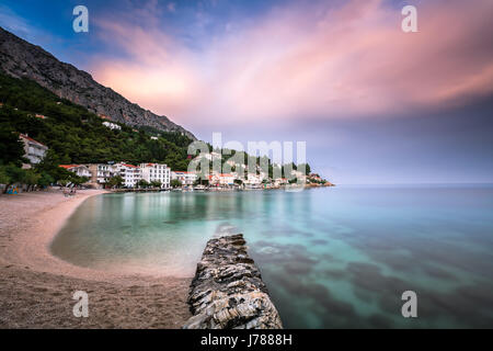 Bellissima spiaggia adriatica e villaggio Mimice su Omis Riviera in Dalmazia, Croazia Foto Stock