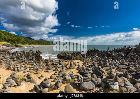 Stacked rocce di bilanciamento sulla spiaggia tra Cairns e Port Douglas, Queensland, Australia Foto Stock