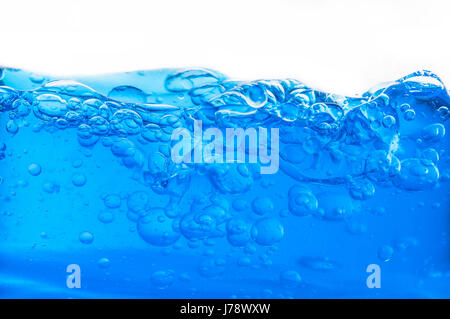 La macro immagine mostra underwater bolle che salgono da acqua blu Foto Stock