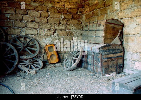 Antiche cassapanche in legno stand uno per uno e la ruota è su di essi Foto Stock