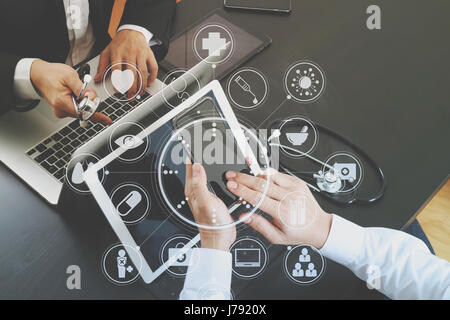 Medical co il concetto di lavoro,medico lavora con smart phone e tavoletta digitale e computer portatile alla riunione con il suo team in ufficio moderno all'ospedale wit Foto Stock