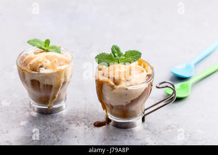 In casa birra fredda caffè ghiacciato con salsa di caramello su sfondo grigio chiaro, semplice ed elegante dessert estivo Foto Stock