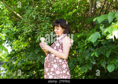 Donna incinta che pongono in estate park. Foto Stock