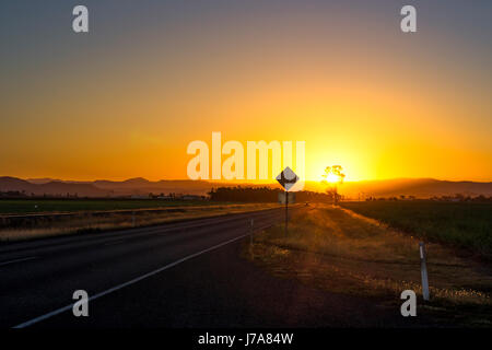 Australia, Queensland, paesaggio nei pressi di Mackay, strada al tramonto Foto Stock