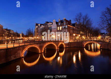 Ponte sul Keizersgracht e Leidsegracht Canal accesa al crepuscolo al crepuscolo. UNESCO - Sito Patrimonio dell'umanità. Keizersgracht, di Leidsegracht, Amsterdam, Net Foto Stock
