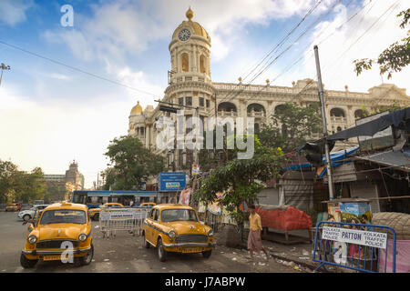 Il traffico della città con autobus e taxi di fronte vintage edificio metropolitano al esplanade il più trafficato della città intersezioni stradali di Kolkata. L'india. Foto Stock