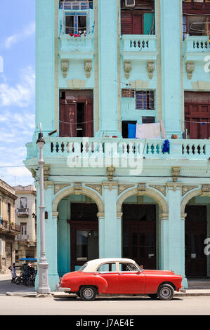 Strada tipica scena in Old Havana : gli edifici colorati e vecchi American Classic Cars driving da Foto Stock