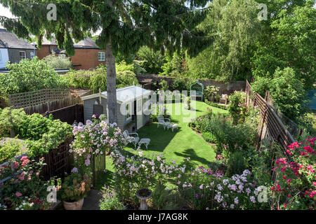 La vista dal balcone verso il basso per inglese il giardino murato con Summer house e arco di rose Foto Stock