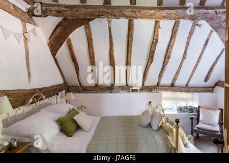 Con soffitti a volta la camera da letto principale con le antiche travi e letto di ferro battuto dal letto di ferro azienda Foto Stock