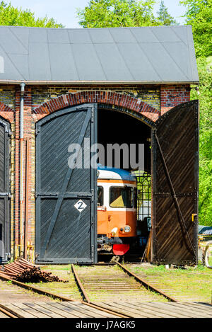 Brosarp, Svezia - 18 Maggio 2017: documentario della pubblica storica area della stazione ferroviaria. La parte anteriore di un vecchio orange vintage vagone ferroviario visibile attraverso un ope Foto Stock