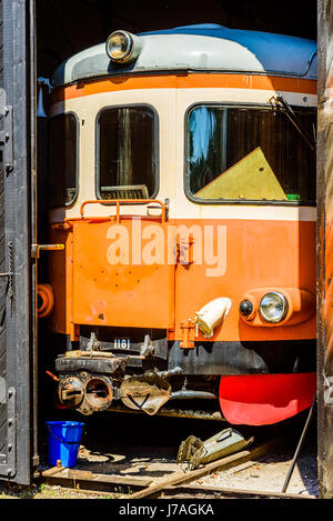 Brosarp, Svezia - 18 Maggio 2017: documentario della pubblica storica area della stazione ferroviaria. La parte anteriore di un vecchio orange vintage vagone ferroviario visibile attraverso un ope Foto Stock