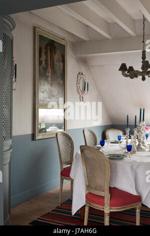 Argenteria candelieri sul tavolo da pranzo con angolo armadio con francese del XVIII secolo trumeau mirror Foto Stock