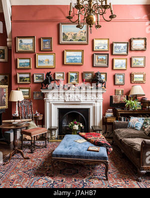 Una collezione di Julian Barrow dipinti al di sopra di un camino recuperati pezzo. Raggruppati intorno sono un Victorian bergere divano e Charles II sedia in stile. Th Foto Stock