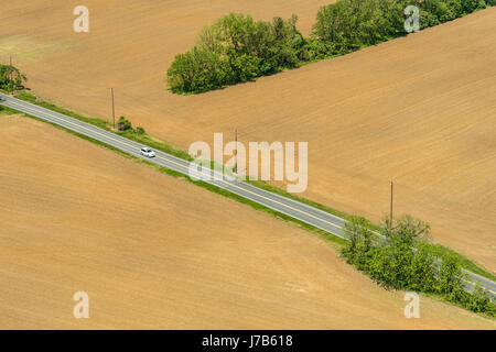 Vista aerea della sola auto sulla strada di campagna di guida attraverso i terreni agricoli, Pennsylvania, STATI UNITI D'AMERICA Foto Stock