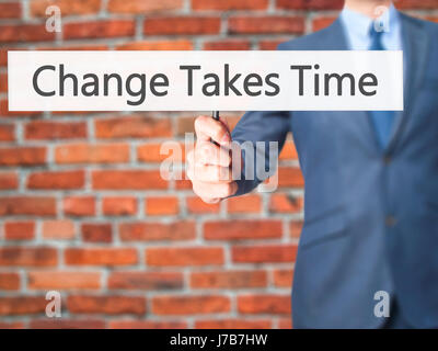 Il cambiamento richiede tempo - Imprenditore mano azienda segno. Business, tecnologia internet concetto. Stock Photo Foto Stock