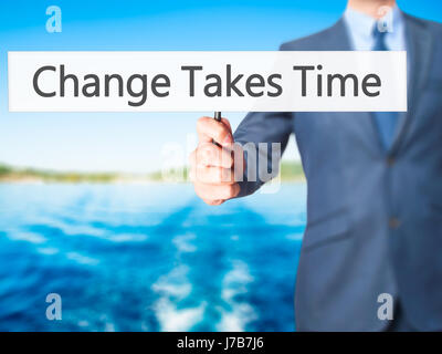 Il cambiamento richiede tempo - Imprenditore mano azienda segno. Business, tecnologia internet concetto. Stock Photo Foto Stock