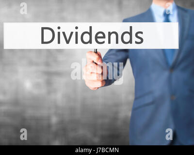 Dividendi - Imprenditore mano azienda segno. Business, tecnologia internet concetto. Stock Photo Foto Stock