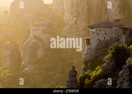 Bellissimo tramonto panoramico vista del Rousanou (St. Barbara) e il Monastero di San Nicola Anapausas monastero su una colonna monolitica in Meteora, Grecia Foto Stock