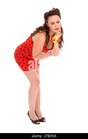 Donna nibble lollipop pinup donna considerare dolce meditativo marrone femmina Foto Stock