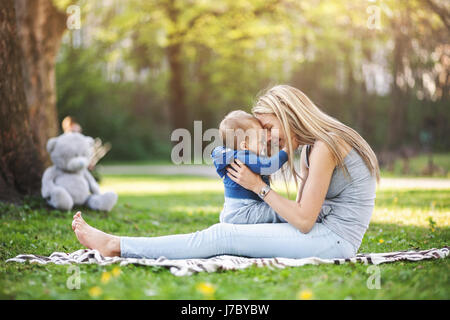 Felice madre con il suo bimbo di un anno all'aperto in un parco Foto Stock