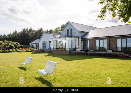 Weatherboard esterno dipinto in grigio per aiutare blend al paesaggio naturale Foto Stock