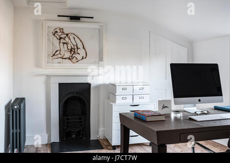 Chic home office con pavimento in legno e incorniciati acquerello da Ryan McElhinney, il piano di lavoro è Philippe Hurel e il deposito bokes da Ikea Foto Stock