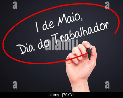 Man mano che scrive 1 de Maio, dia do Trabalhador (in portoghese: 1 maggio, Giornata del Lavoro) con pennarello nero su schermo visivo. Isolato su nero. Business, te Foto Stock