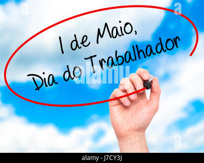 Man mano che scrive 1 de Maio, dia do Trabalhador (in portoghese: 1 maggio, Giornata del Lavoro) con pennarello nero su schermo visivo. Isolato su sky. Business, tech Foto Stock