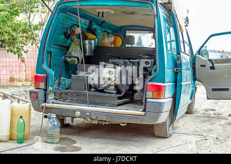 Alimentate a benzina generatore portatile dare corrente elettrica è collocato nel lato posteriore di grandi cargo FURGONE. Foto Stock