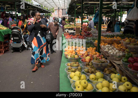 Multiculturale di scena a Bullring mercato aperto, all'aperto del mercato alimentare nella zona centrale di Birmingham, Regno Unito. Il mercato aperto offre una grande varietà di frutta e verdura fresca, tessuti, oggetti per la casa e prodotti stagionali. Il Bull Ring mercato aperto ha 130 bancarelle. Foto Stock