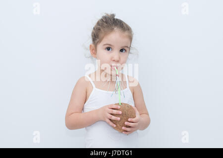 Kid ragazza bere pipetta di cocco Foto Stock