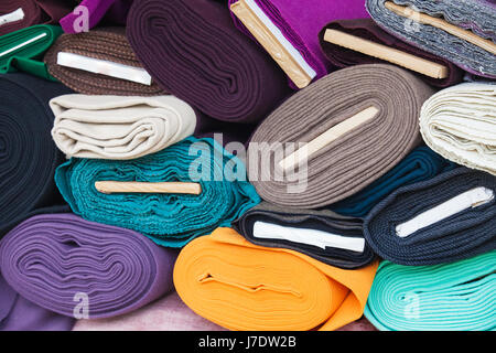 Rotoli di tessuti e prodotti tessili in un negozio della fabbrica. Multi colori diversi e sul mercato. Foto Stock