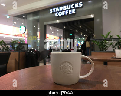 Cracovia in Polonia - 21 Maggio 2017: Starbucks Coffee segno e tavoli da caffè di fronte alla caffetteria ingresso. Starbucks Corporation è un Americano famo Foto Stock