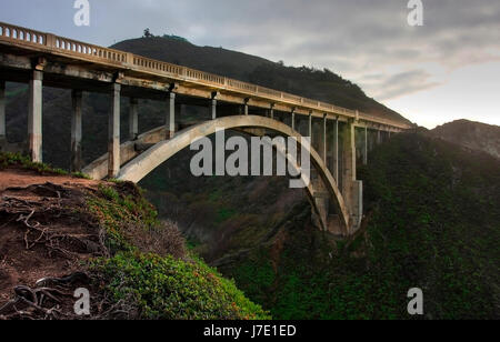 Un'immagine della famosa Bixby Bridge da un basso punto di osservazione. Girato in una nebbiosa giornata uggiosa. Foto Stock