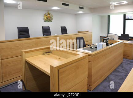 Interno di un moderno, inglese aule di tribunale. Mostra di giudici e magistrati da banco e testimoniare la casella (con la Bibbia) in primo piano Foto Stock